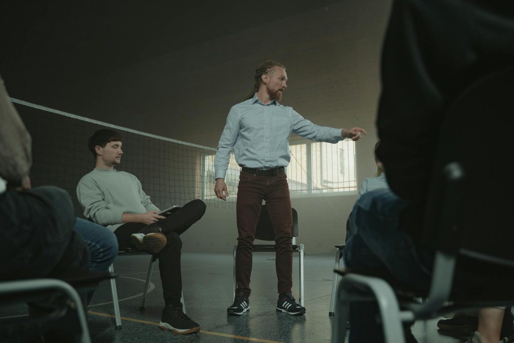 A group therapy session indoors with diverse adults engaging in discussion and support.